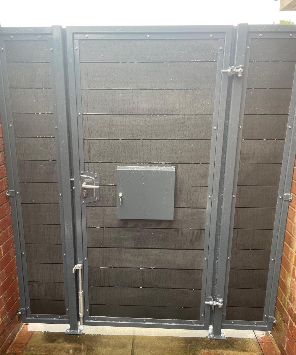 Rear of charcoal black composite gates featuring integral post box fitted in Lancashire area.