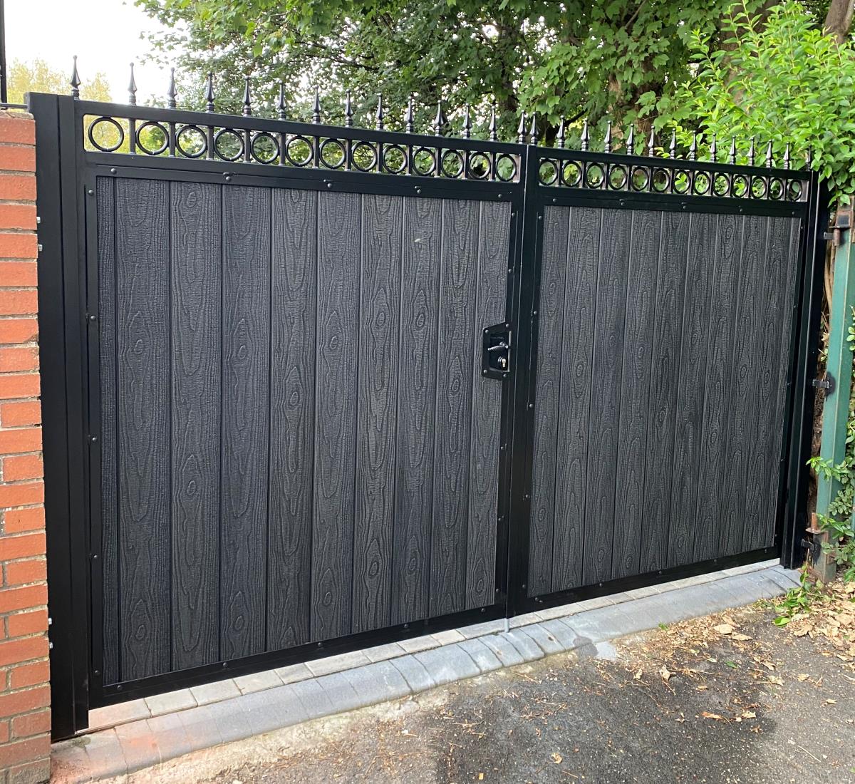 Double ornate driveway gates with embossed black composite infill in Bolton, Manchester.