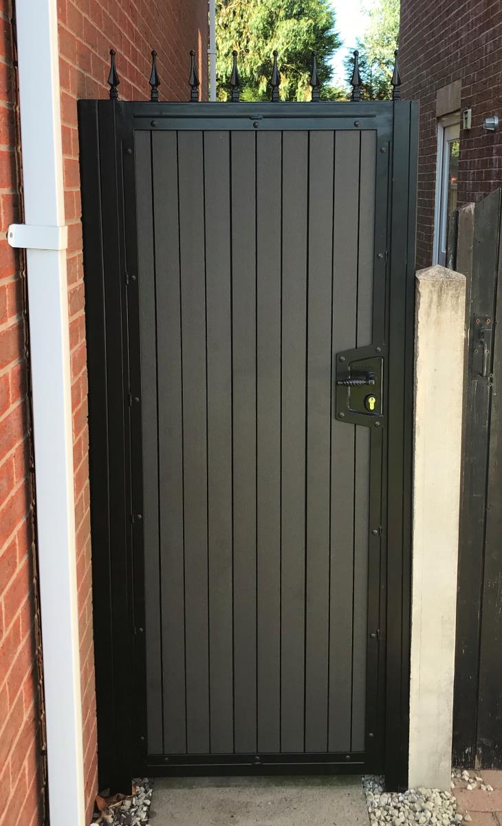 Integral locking on composite alley gate in black powder coated frame topped with finials in Macclesfield.
