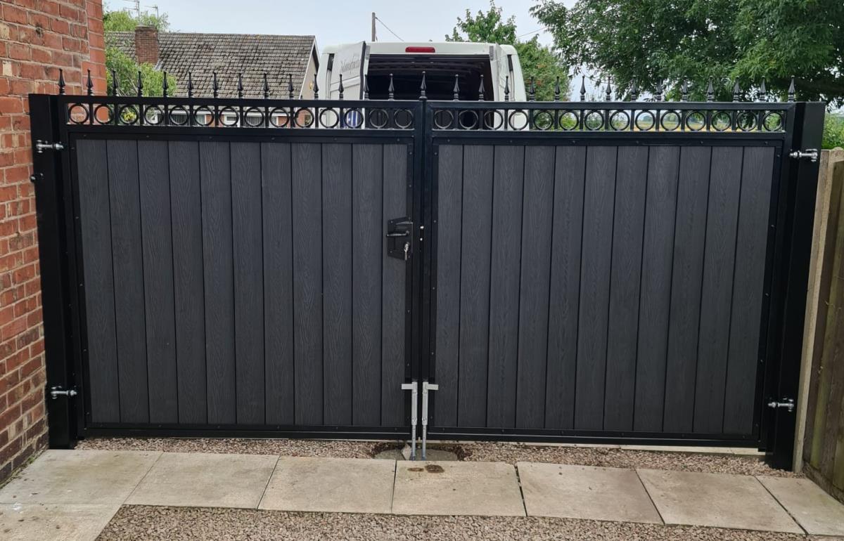 Ornate steel framed composite gates with wood grain embossed infill fitted to a Leyland home.