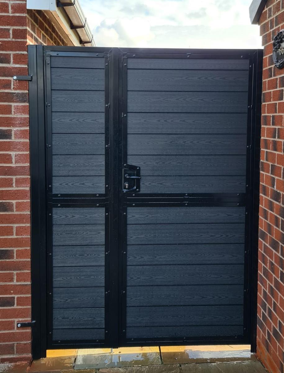 Black composite gates in powder coated black steel frame with side panel installed in Leyland.
