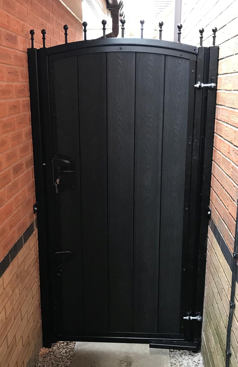 Arched composite gate with embossed timber infill fitted to alley of property in the Manchester area.