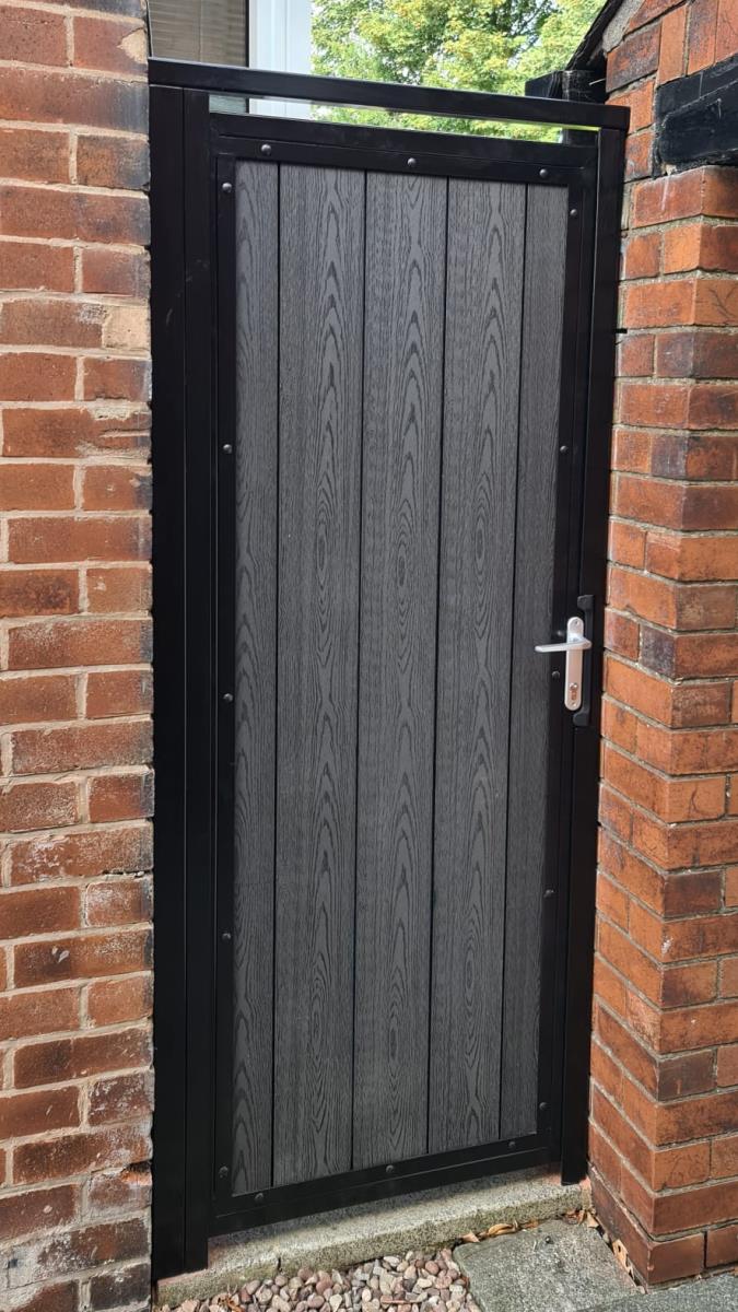 Black steel framed gates with timber infill style composite board and integral locking for Altrincham property.