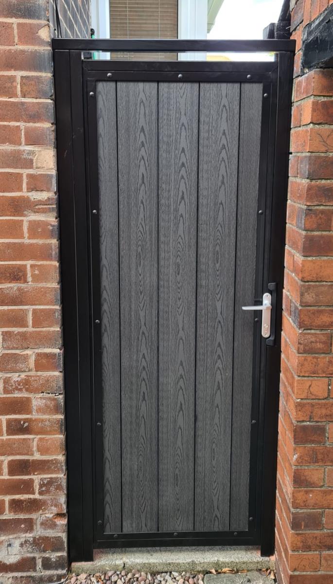 Black steel framed gates with timber effect composite infill, integral handles and locks fitted in Wigan.